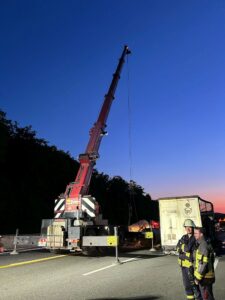 Feuerwehr und Bergungskräfte im nächtlichen Einsatz mit schwerem Kranfahrzeug
