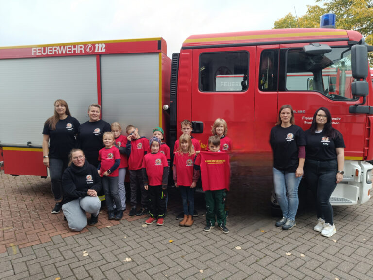 Gruppe von Personen vor einem roten Feuerwehrauto