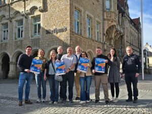 Eine Gruppe von zehn Personen steht vor dem Rathaus in Bückeburg und hält Plakate für den Filmwettbewerb #redemit hoch.