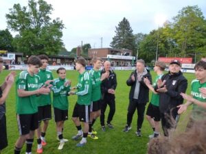 Fußballspieler in grünen Trikots klatschen nach dem Spiel.
