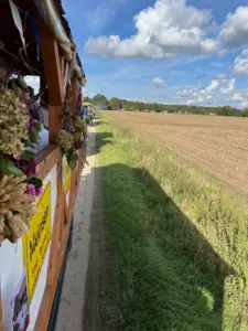 Blick von einem geschmückten Erntewagen auf Traktoren und weitere Wagen auf einem Feldweg bei Meinsen-Warber